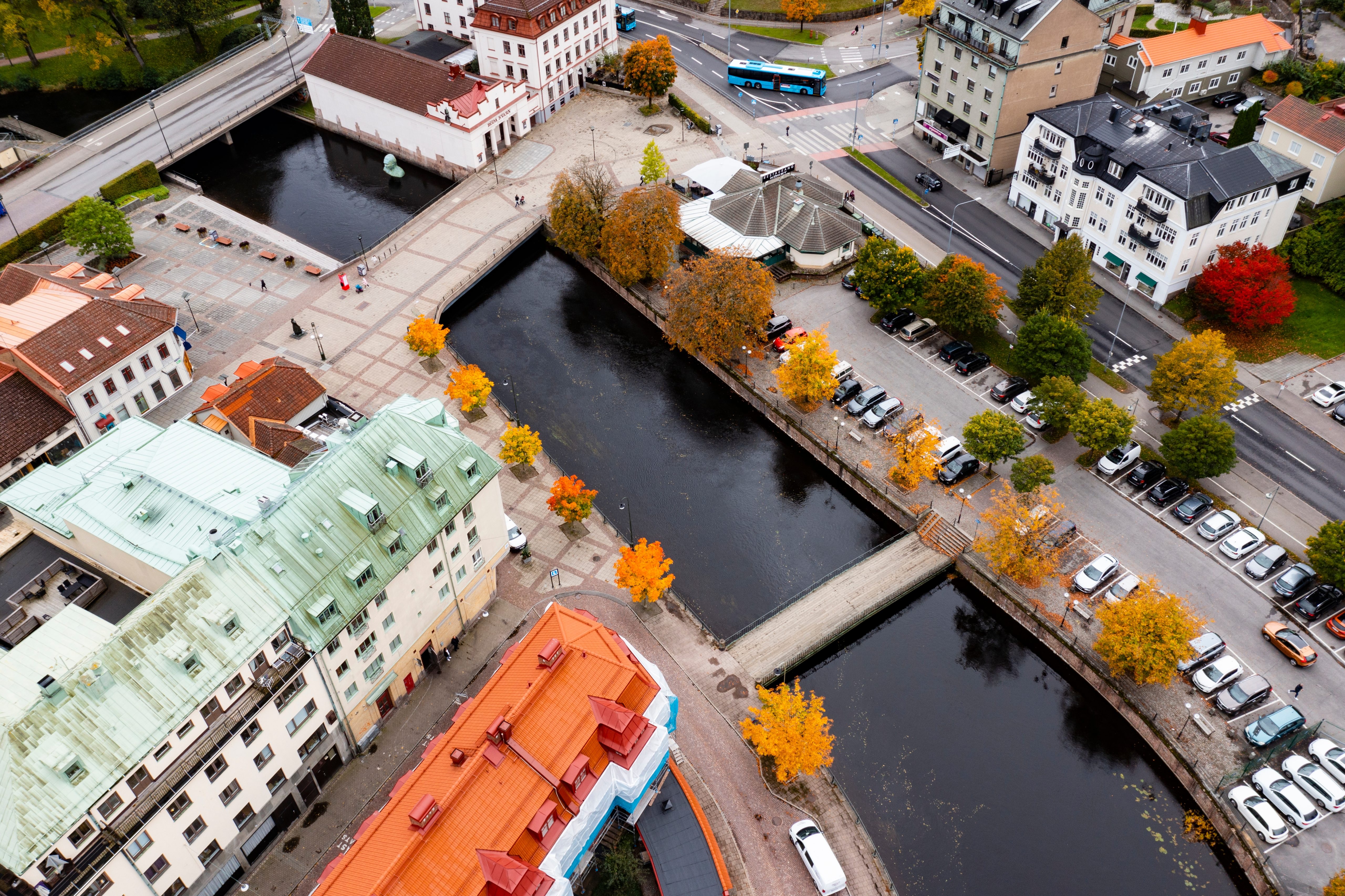 Borås ovanifrån under hösten, hustak, parkeringar och en fors som går genom staden med broar över.
