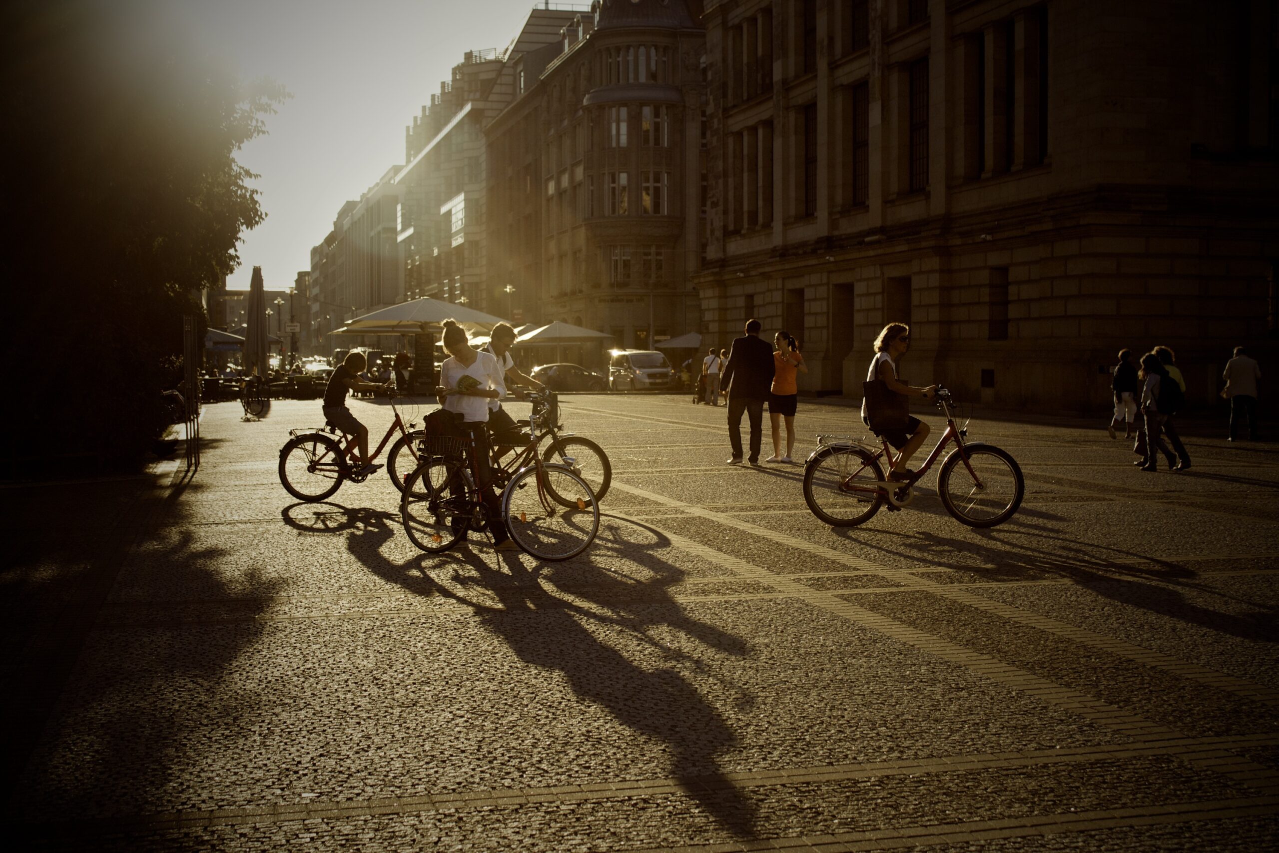 Passerande cyklister på ett torg en sommarkväll.